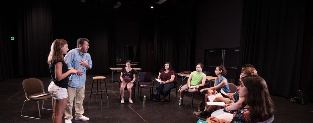 Professor teaching a group of students in a theater